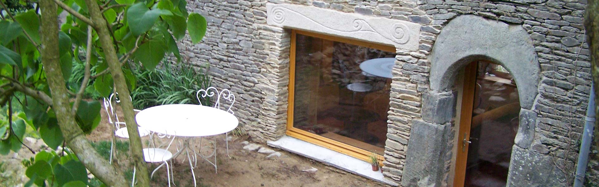 Ouverture porte-fenêtre sur une maison traditionnelle en granit